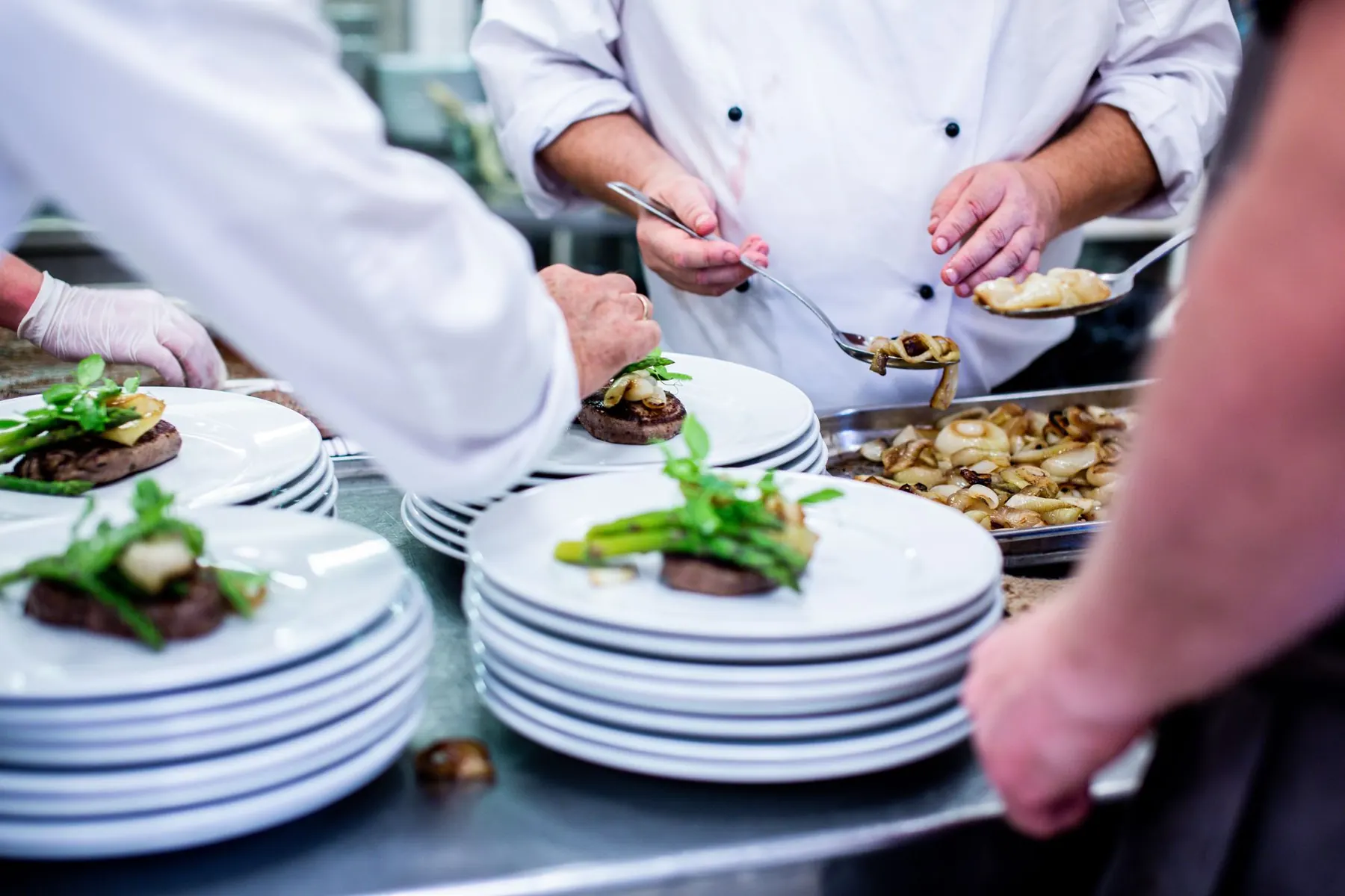 Chefs plating dishes in a professional kitchen